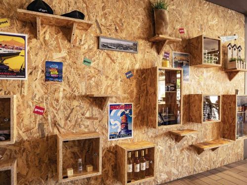 a stone wall with pictures and posters on it at greet Hotel Marseille Provence Aéroport in Vitrolles