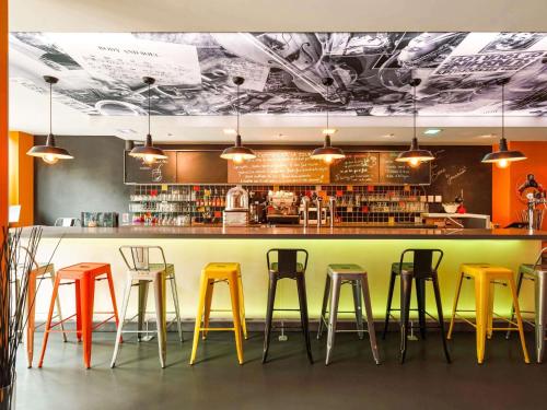 a bar with colorful stools in a restaurant at Greet Hotel Lyon Confluence in Lyon