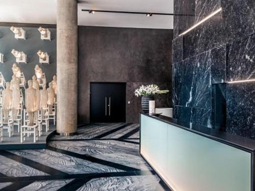 a lobby with a waiting area with tables and chairs at SLS Buenos Aires Puerto Madero in Buenos Aires