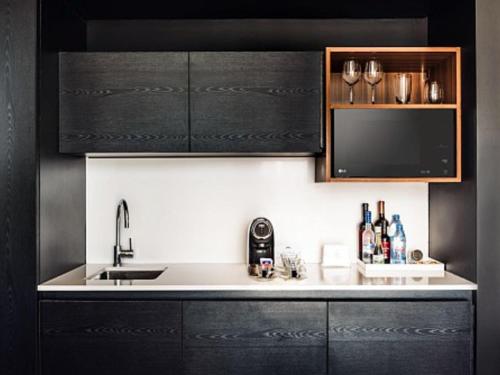 a kitchen with black cabinets and a sink at SLS Buenos Aires Puerto Madero in Buenos Aires