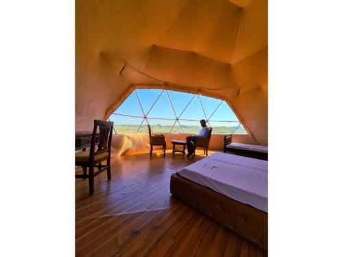 a person sitting at a table in a room with a window at Crystal Resort in Sām
