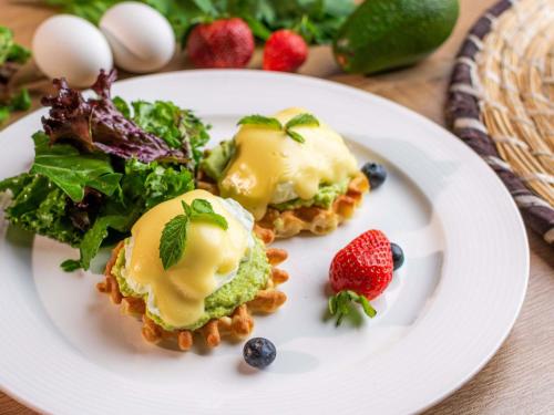 two waffles with ice cream and fruit on a plate at Shaden Resort in AlUla