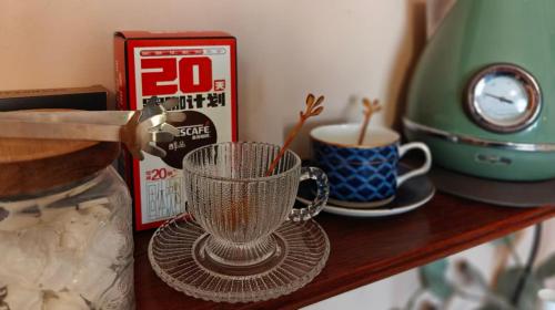 a glass cup on a shelf next to a coffee maker at koko's garden and cats --4mins walk from jingjusi metro st ation, English-speaking service in Chengdu