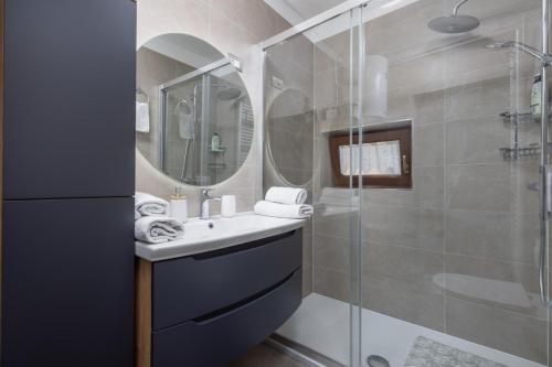 a bathroom with a sink and a shower with a mirror at Apartaman Goga in Lokve
