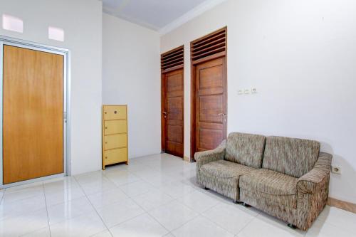 a living room with a chair and a closet at SPOT ON Podomoro Homestay in Yogyakarta