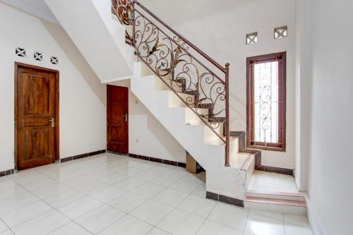a staircase in a house with a wooden door at SPOT ON Podomoro Homestay in Yogyakarta