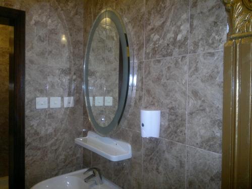 ein Bad mit einem Waschbecken und einem Spiegel in der Unterkunft شقق ضيافة خاصة in Yanbu