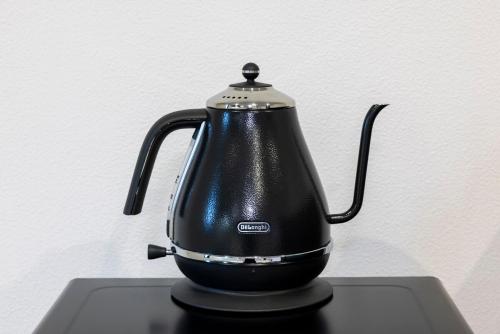 a black tea kettle sitting on top of a stove at Amp Flat ノワール呉服 in Fukuoka