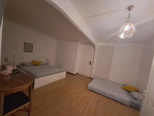 a room with two beds and a table in it at Schlafmöglichkeit in Luzern