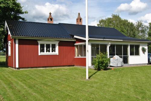a red and white house with a yard at Orsastuguthyrning-Hansjö in Orsa