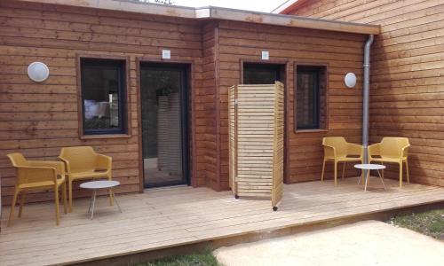a cabin with chairs and tables on a wooden deck at Cap Océan in Seignosse