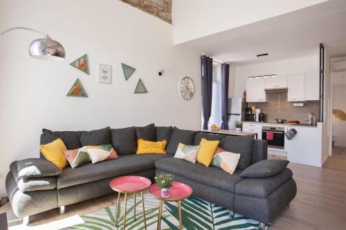 - un salon avec un canapé gris et des oreillers colorés dans l'établissement Villa Sandrine, à Calvi