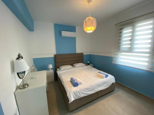 a bedroom with a bed and a table and a lamp at Garden View Two Bedroom Apartment in Caesar Resort & SPA, Long Beach in Perivolia tou Trikomou