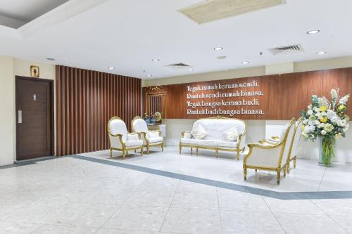 a waiting room with white chairs and a sign at Sunday Malacca Formerly Tun Fatimah in Malacca