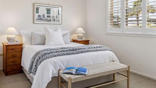 a bedroom with a bed with two blue shoes on it at Point Paradiso - Glorious waterfront in Yamba