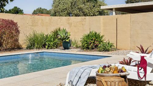 a swimming pool with a basket of fruit next to it at Point Paradiso - Your Ultimate Family Waterfront Escape - Holiday Yamba in Yamba