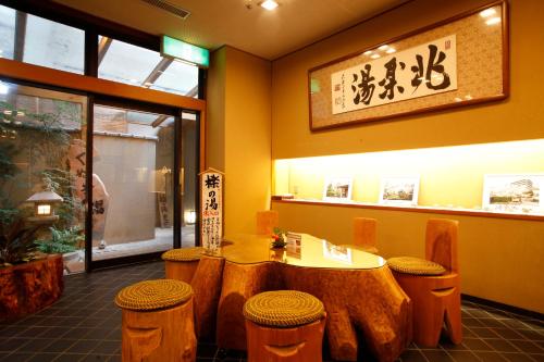 a restaurant with a table and stools in a room at Ginsuisou Choraku in Kobe