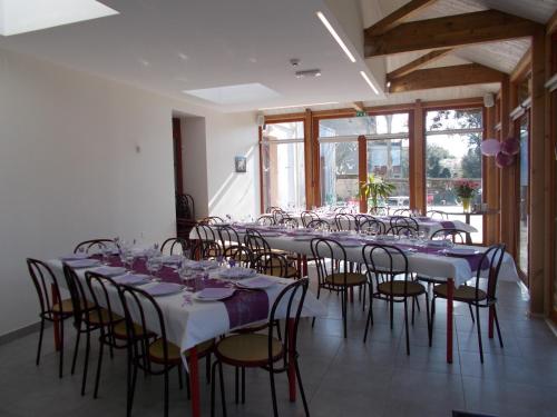 uma fila de mesas e cadeiras num quarto em La Brise de Mer em Saint-Michel-Chef-Chef