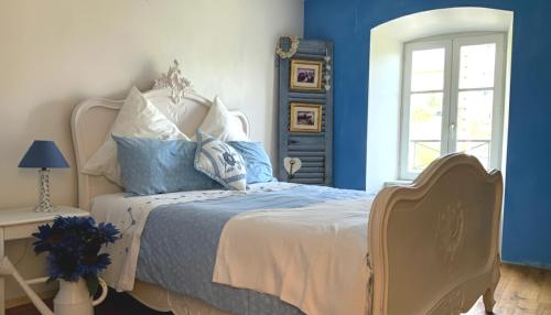 a bedroom with a bed with blue walls and a window at Charming Country Getaway, Balcony, Views, Office in Le Monestier