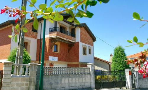 una casa de ladrillo con una valla delante de ella en Apartamentos Copi Villa de Suances, en Suances