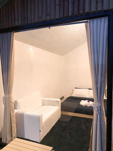 a living room with a couch and a window at ม่านป่ามองเขาเฮ้าส์ in Ban Sop Mae Klang