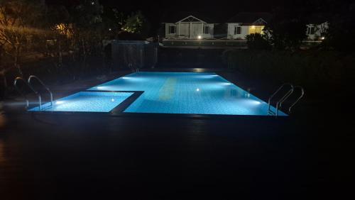 a swimming pool lit up at night at Holiday Heaven Munnar in Chinnakanal