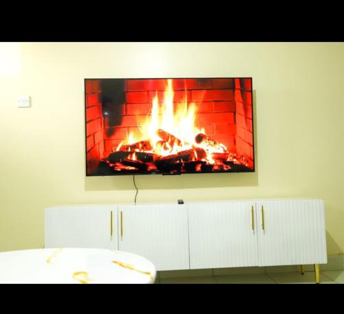 MachakosにあるCosy Nest Stays Machakosの壁にテレビがかかっていて、暖炉に火が灯っている