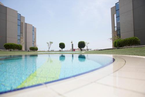 an empty swimming pool in front of a building at Faris Villas للعائلات فقط-الصفحة الرسمية لمنتجع فلل فارس in Al Khīrān