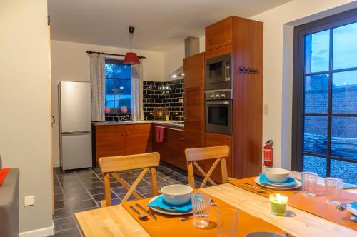 a kitchen with a table and chairs and a kitchen with a window at Het Kloosterzicht in Borgloon