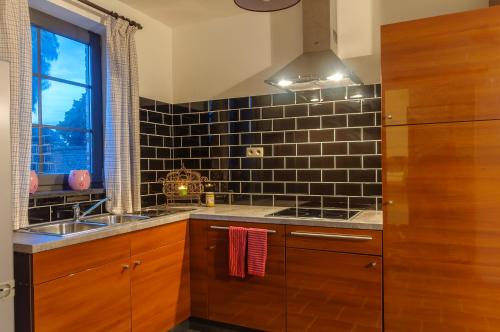 a kitchen with wooden cabinets and a sink and a window at Het Kloosterzicht in Borgloon