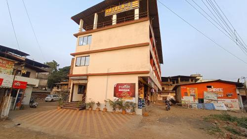 a tall building on a street in a city at Hotel A1 family restaurant Bar & Lodge in Birvādi