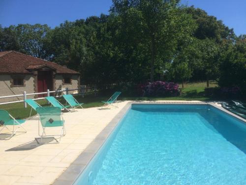 a swimming pool with chairs and a house at Chateau De Piedouault in Jallais