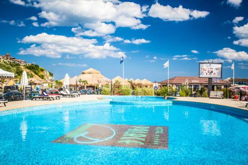 a swimming pool at a resort with a blue sky at Hotel Palace Marina Dinevi in Sveti Vlas