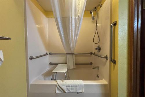 a small bathroom with a bath tub and a shower at Super 8 by Wyndham Jacksonville in Jacksonville