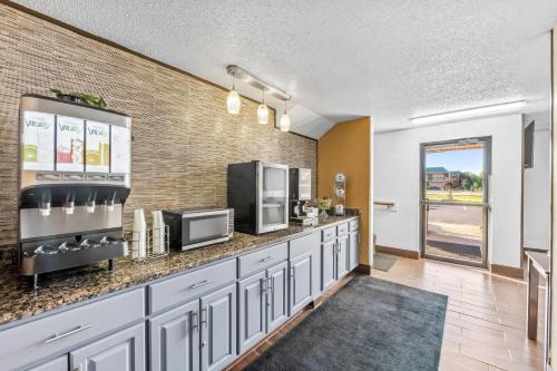 a kitchen with a counter with a microwave and a tv at Super 8 by Wyndham Franklin in Franklin