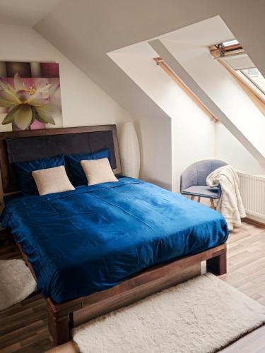 a bedroom with a blue bed and a chair at Cozy Little Penthouse Free Parking, Self Check In in Tallinn