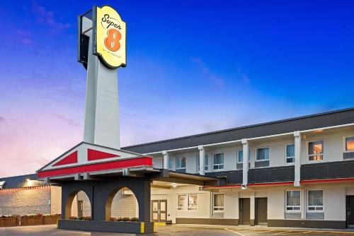 a hotel with a clock tower in a parking lot at Super 8 by Wyndham Thunder Bay in Thunder Bay