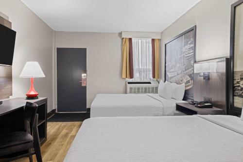 a hotel room with two beds and a desk at Super 8 by Wyndham Thunder Bay in Thunder Bay