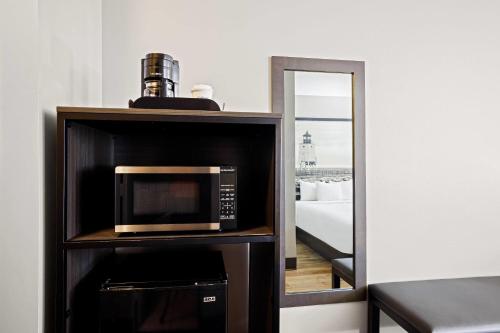 a microwave sitting on a shelf next to a mirror at Super 8 by Wyndham Thunder Bay in Thunder Bay
