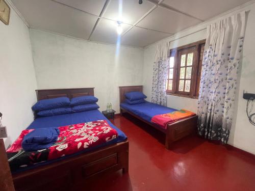a bedroom with two beds and a window at Liptora Homestay in Bandarawela