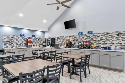 a restaurant with tables and chairs and a bar at Days Inn by Wyndham Simpsonville in Simpsonville
