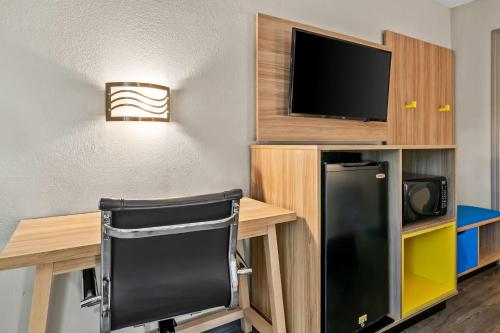 a room with a desk with a tv and a refrigerator at Days Inn by Wyndham Simpsonville in Simpsonville