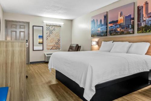 a hotel room with a bed and a chair at Days Inn by Wyndham Simpsonville in Simpsonville