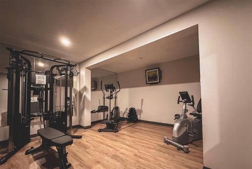 a gym with several exercise equipment in a room at The Jordan Hotel Ramada by Wyndham in Jordan