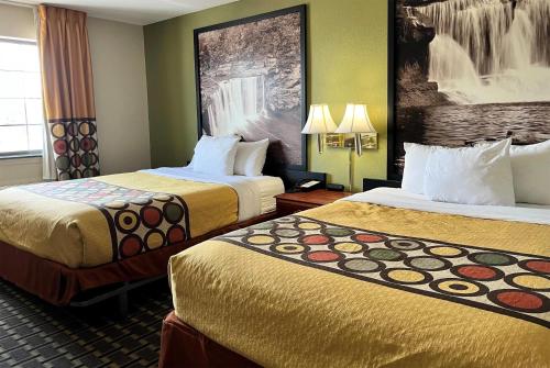 a hotel room with two beds in a room at Super 8 by Wyndham Madison IN in Madison