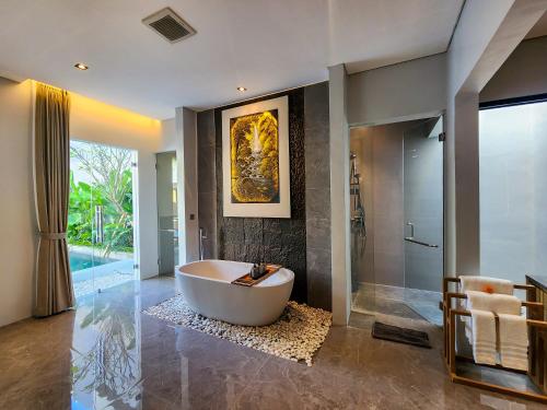 a large bathroom with a tub and a shower at Villa Narda Seminyak by Nagisa Bali in Legian