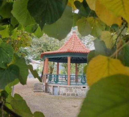 a gazebo with a red roof in a park at Quatro Ponto Cinco in Caldelas