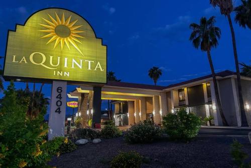 a sign for a la quinta inn at night at La Quinta Inn by Wyndham Tucson East in Tucson