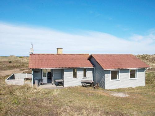 a small white house with a red roof on a field at 6 person holiday home in Henne-By Traum in Henne Strand