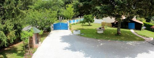an empty road with a yard with trees and a fence at Chambre d'Hôtes au Sargaillon in Pouillon